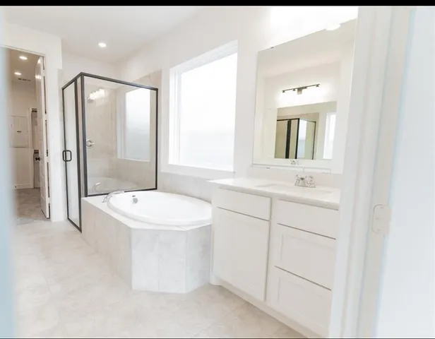 a bathroom with a toilet a sink a mirror a window and tub