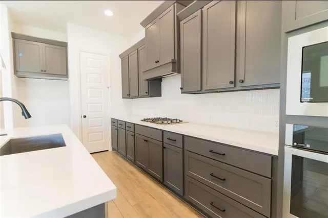 a kitchen with cabinets appliances and a counter space