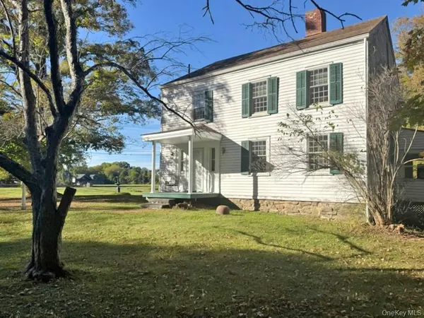 a view of a house with backyard and a tree