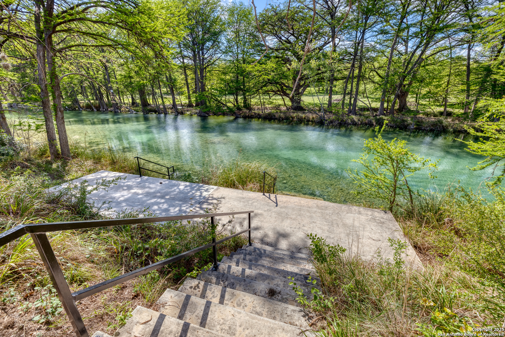 405 Ridge Loop Rio Frio, TX 78879 - Photo 13 of 32 a view of a lake with a yard and large trees