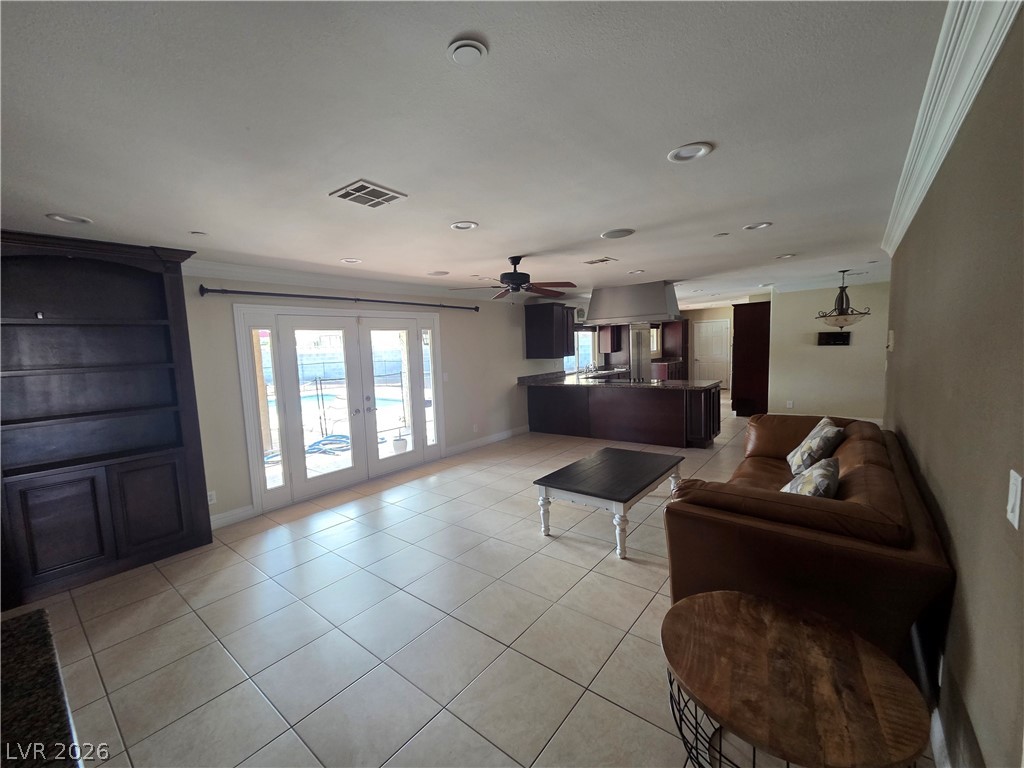 3381 Westwind Road Las Vegas, NV 89146 - Photo 17 of 52 Porcelain tile floors flow into an open-concept living area with French doors that open to a refreshing pool.