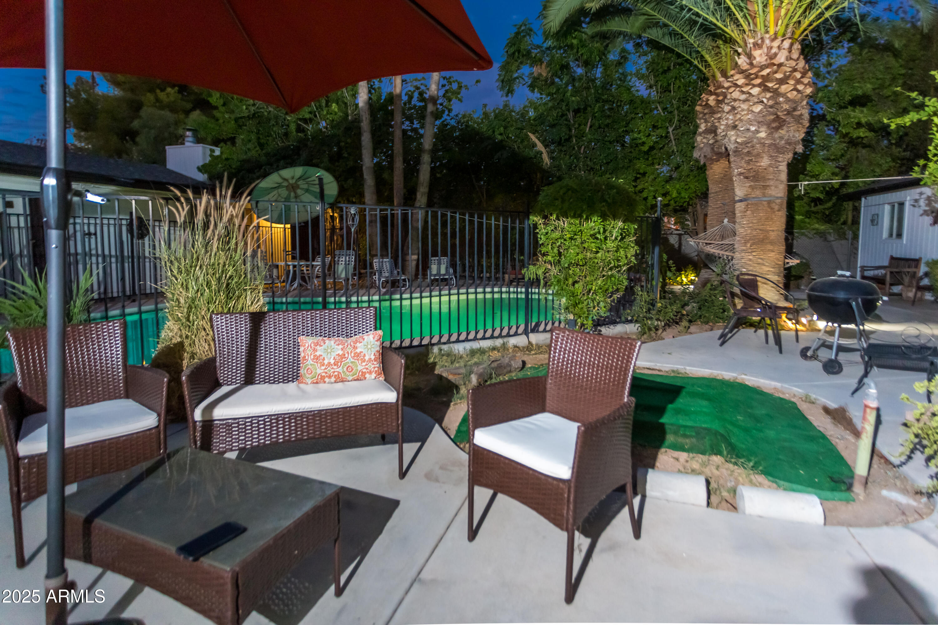 37 West Pasadena Avenue Phoenix, AZ 85013 - Photo 27 of 37 a view of a patio with couches table and chairs under an umbrella with a small garden