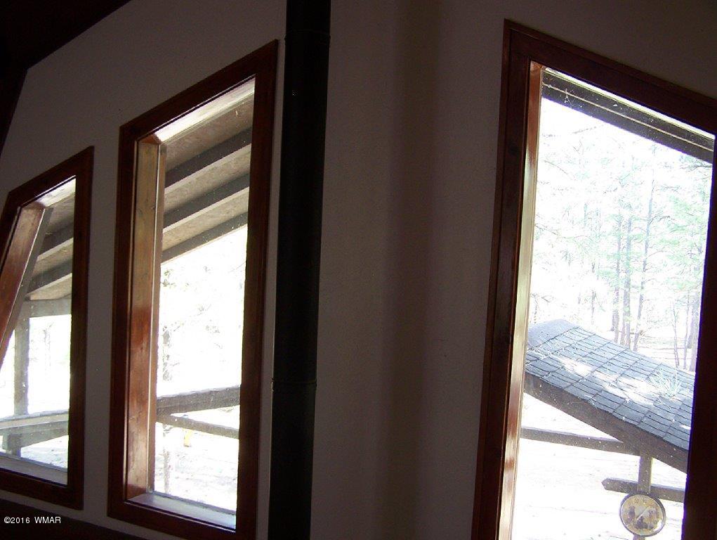 3156 Chevelon Road Overgaard, AZ 85933 - Photo 14 of 46 a view of an empty room with wooden floor and windows