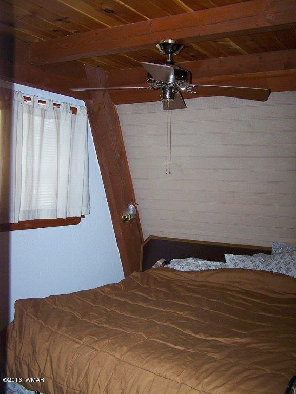 3156 Chevelon Road Overgaard, AZ 85933 - Photo 17 of 46 a bedroom with a bed and a window