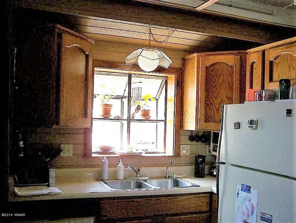3156 Chevelon Road Overgaard, AZ 85933 - Photo 6 of 46 a kitchen with a refrigerator and a window