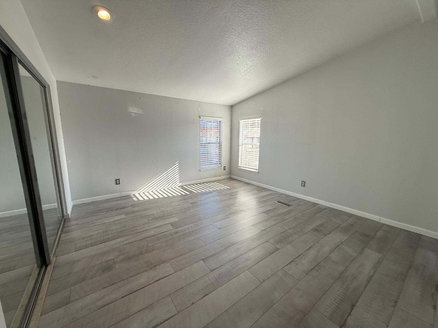 908 Atlantic Street, Unit 33 Roseville, CA 95678 - Photo 27 of 31 an empty room with wooden floor and windows
