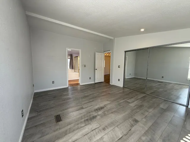 an empty room with wooden floor and window