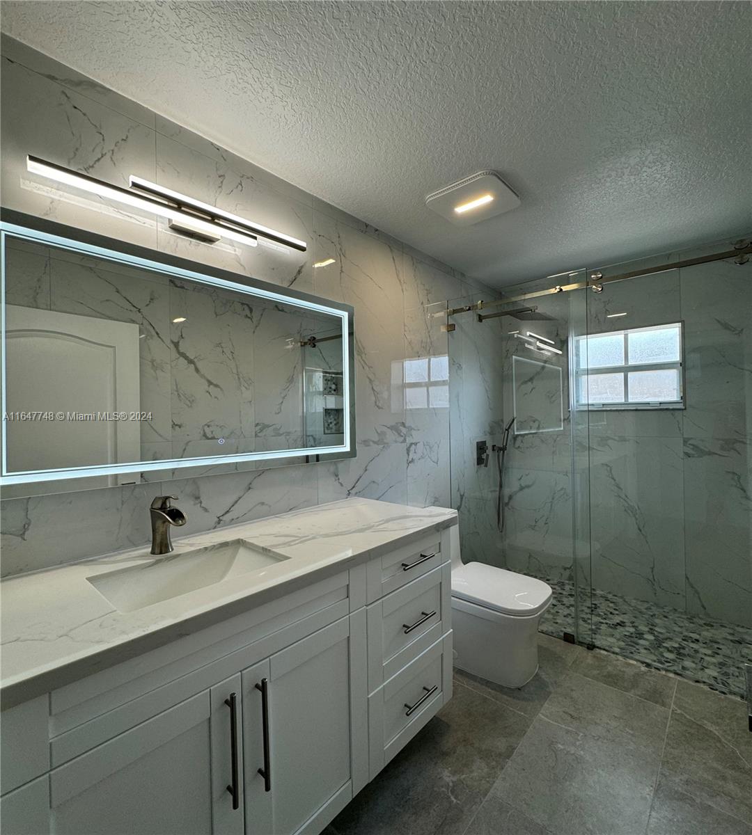 Richmond West Miami, FL 33187 - Photo 3 of 10 a bathroom with a toilet sink double vanity and mirror