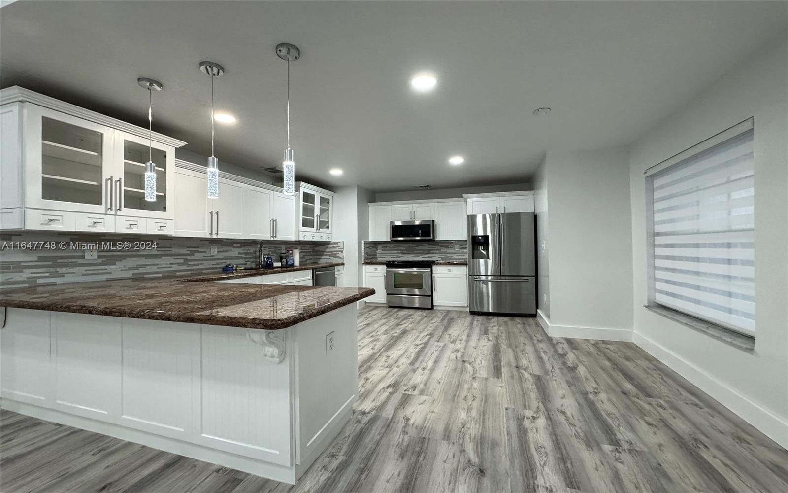 Richmond West Miami, FL 33187 - Photo 5 of 10 a large kitchen with cabinets wooden floor and stainless steel appliances