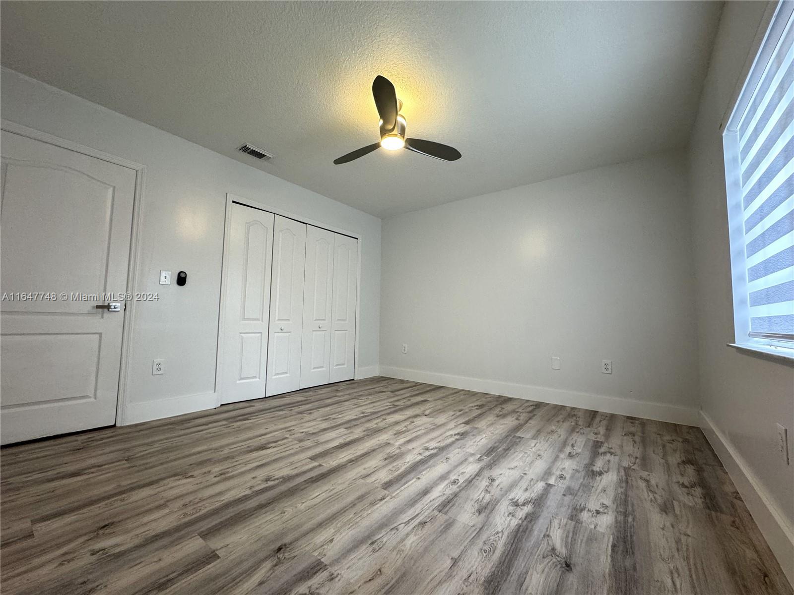 Richmond West Miami, FL 33187 - Photo 7 of 10 wooden floor in an empty room with a window