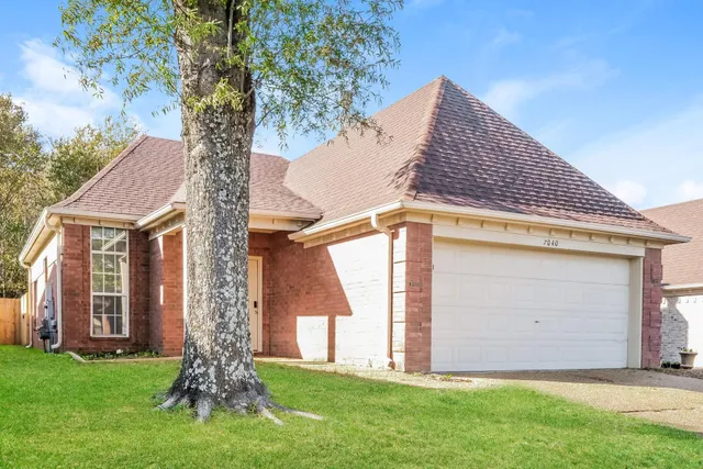 a front view of house with yard and trees