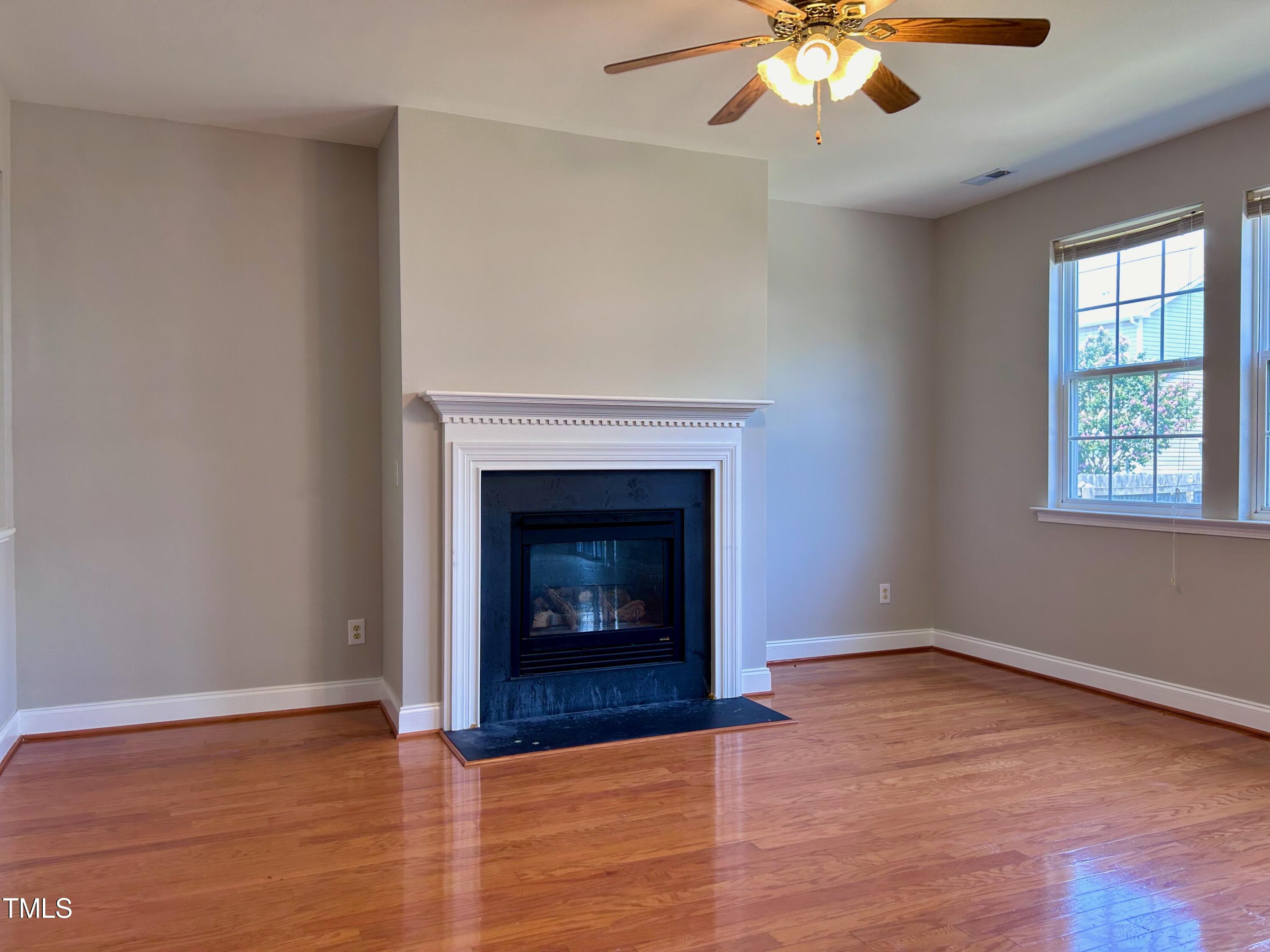 4029 Wester Road Raleigh, NC 27604 - Photo 10 of 37 a view of an empty room with wooden floor fireplace and a window