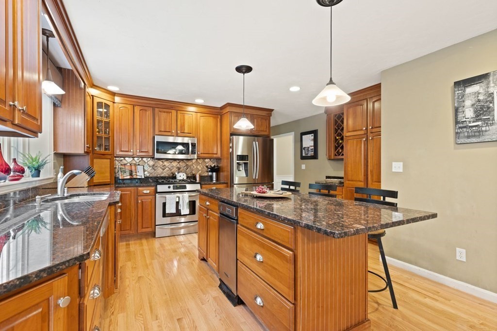 3 Symphony Drive Easton, MA 02356 - Photo 16 of 42 a kitchen with stainless steel appliances granite countertop wooden cabinets a stove a sink a dining table and chairs