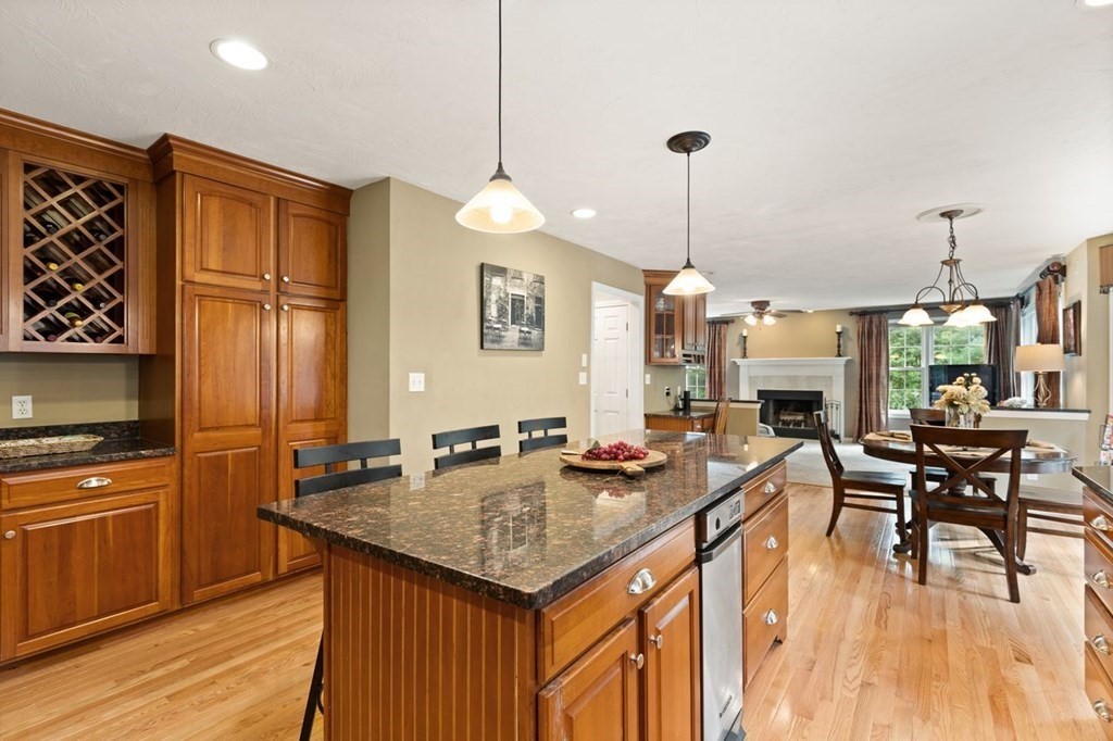 3 Symphony Drive Easton, MA 02356 - Photo 17 of 42 a kitchen with granite countertop a stove a kitchen island a dining table and chairs with wooden floor