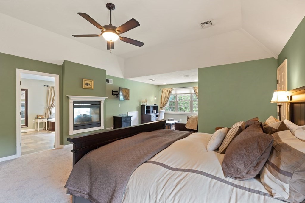 3 Symphony Drive Easton, MA 02356 - Photo 27 of 42 a bedroom with a large bed and a fireplace