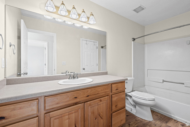 652 West 800 North, Unit 45 Clinton, UT 84015 - Photo 16 of 17 Bathroom featuring a wood-finish vanity with a light-toned countertop, an integrated sink, a large wall-mounted mirror, and a combined tub and shower unit