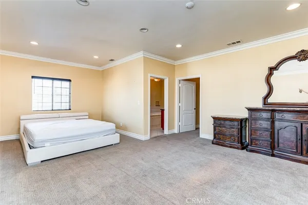 a spacious bedroom with a large bed and a chandelier