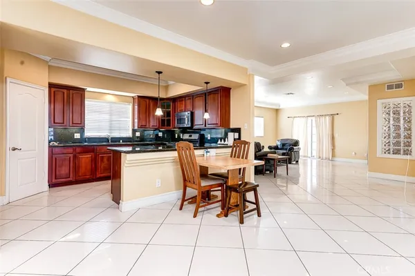 a kitchen with stainless steel appliances granite countertop a stove a sink a dining table and chairs
