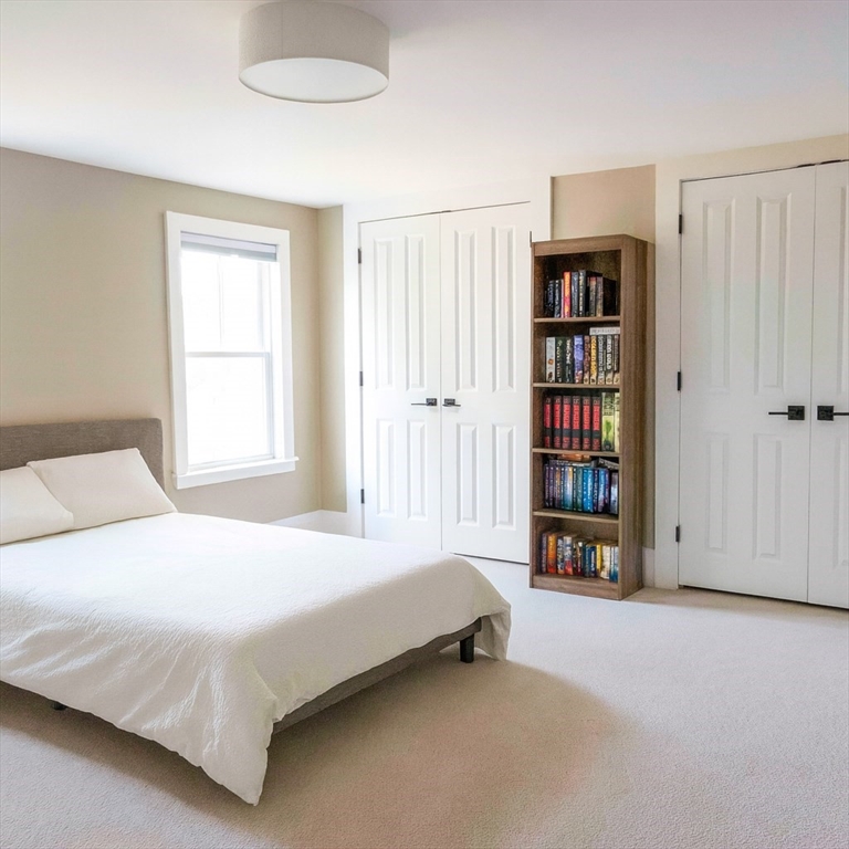 149 High Street, Unit 3 Danvers, MA 01923 - Photo 11 of 19 a bedroom with a bed and a book shelf