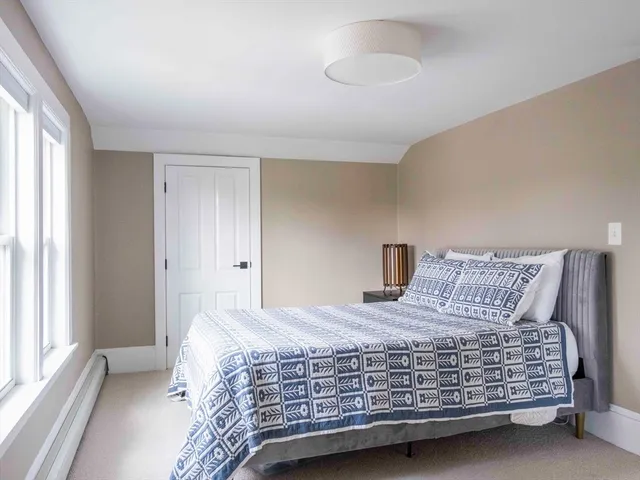 a bedroom with a bed and a large window