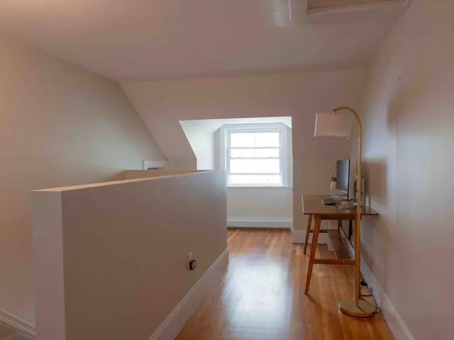 a view of a livingroom with wooden floor and a window