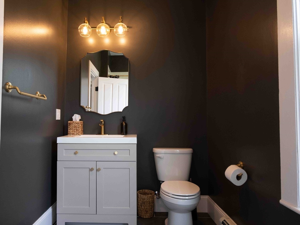 149 High Street, Unit 3 Danvers, MA 01923 - Photo 8 of 19 a bathroom with a toilet sink vanity and mirror