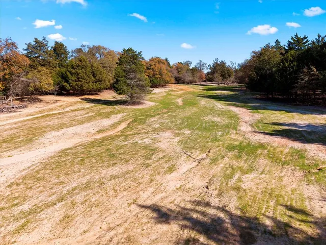 a view of a house with backyard and trees