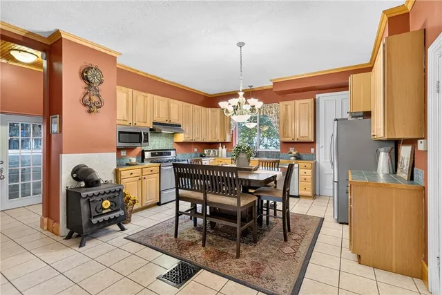 a dining room filled chandelier and kitchen view