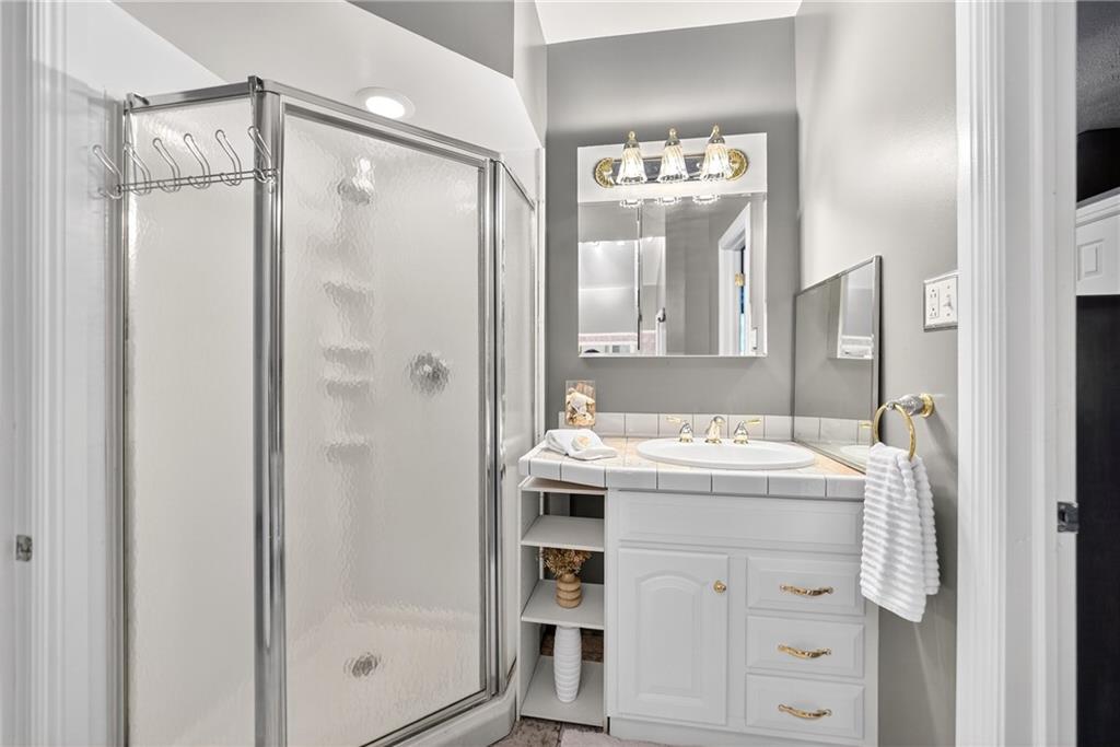 28 Whitaker Street Burgettstown, PA 15021 - Photo 32 of 50 a bathroom with a granite countertop sink mirror and a shower