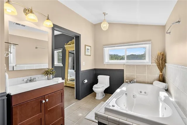 a spacious bathroom with a toilet sink and mirror