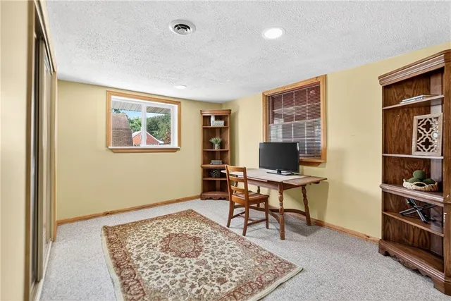 a view of a workspace with furniture and a window