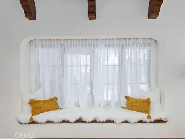 a white bed sitting in a room next to a window