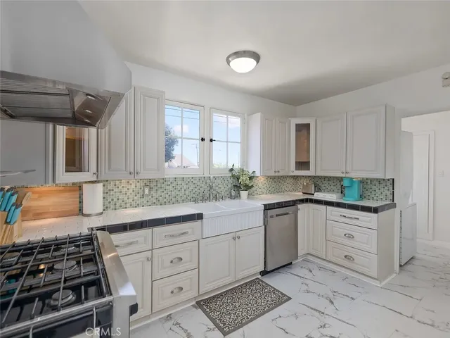 a kitchen with white cabinets and appliances