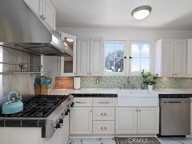 a kitchen with white cabinets and appliances