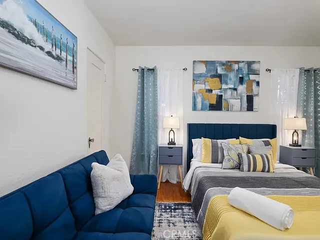 a bedroom with a bed couch and painting on the wall