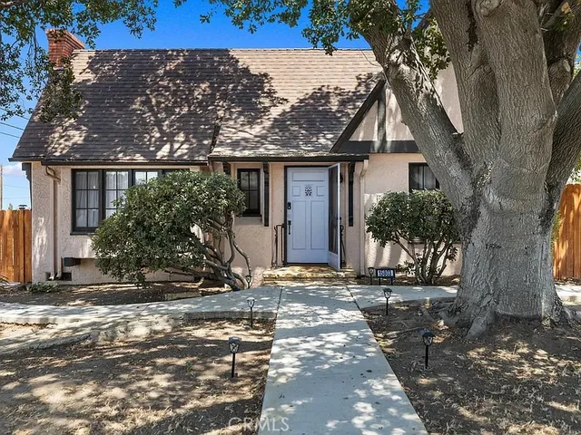 a view of a house with a tree in front
