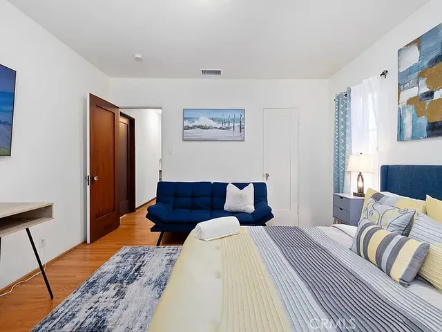 a bedroom with a bed and wooden floor