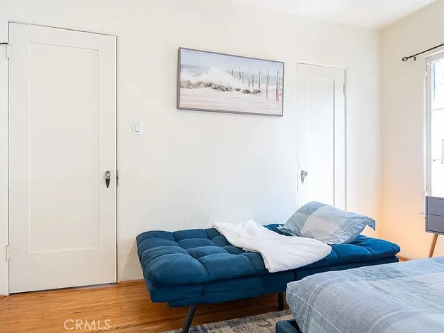 a view of a bedroom with furniture and wooden floor