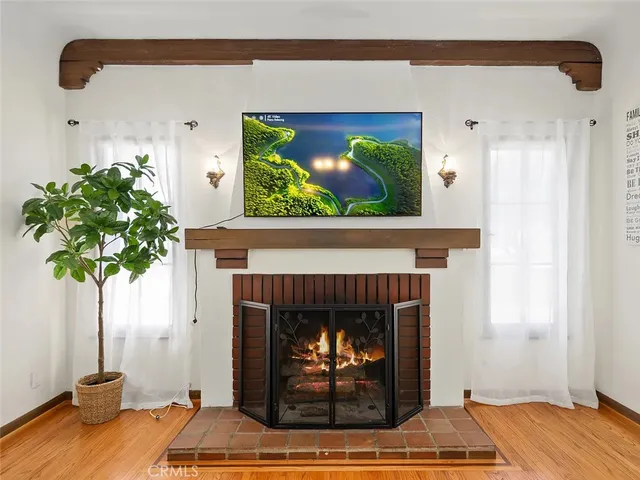 a living room with a fireplace furniture a potted plant and a fireplace