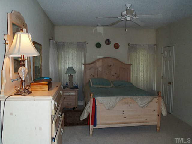5832 Solitude Way Durham, NC 27713 - Photo 3 of 20 a bedroom with a bed and a chandelier