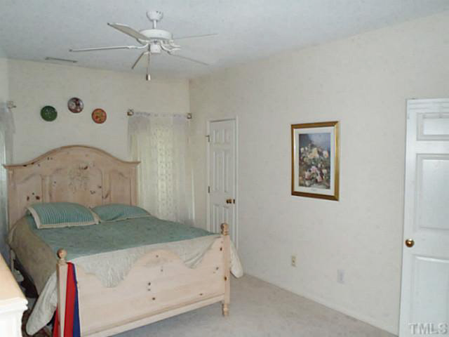 5832 Solitude Way Durham, NC 27713 - Photo 4 of 20 a bedroom with a bed and a table
