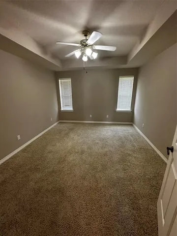 a view of an empty room with a chandelier fan