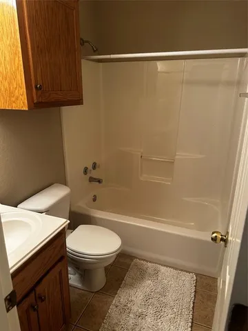 a white toilet sitting next to a bath tub
