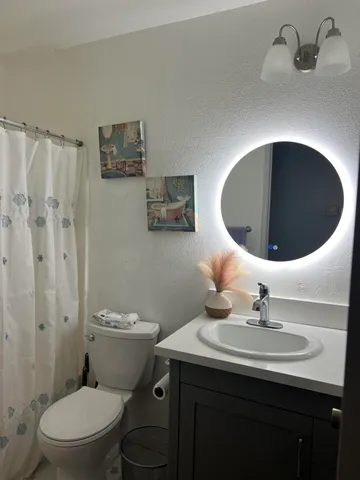 a bathroom with a toilet sink and mirror