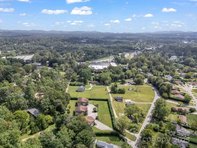 an aerial view of residential houses with outdoor space and swimming pool