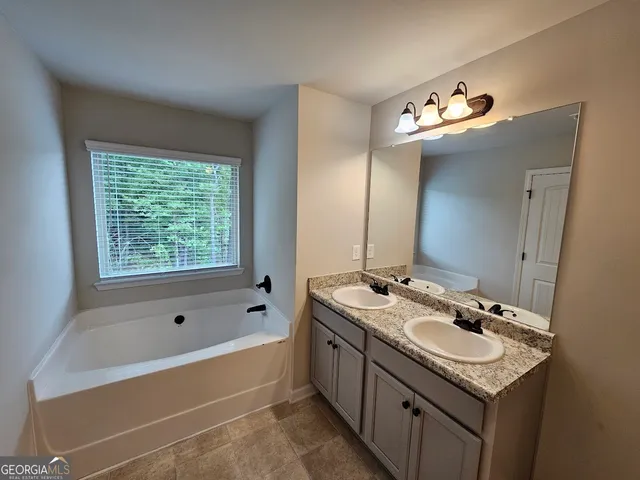 a bathroom with a tub sink and mirror