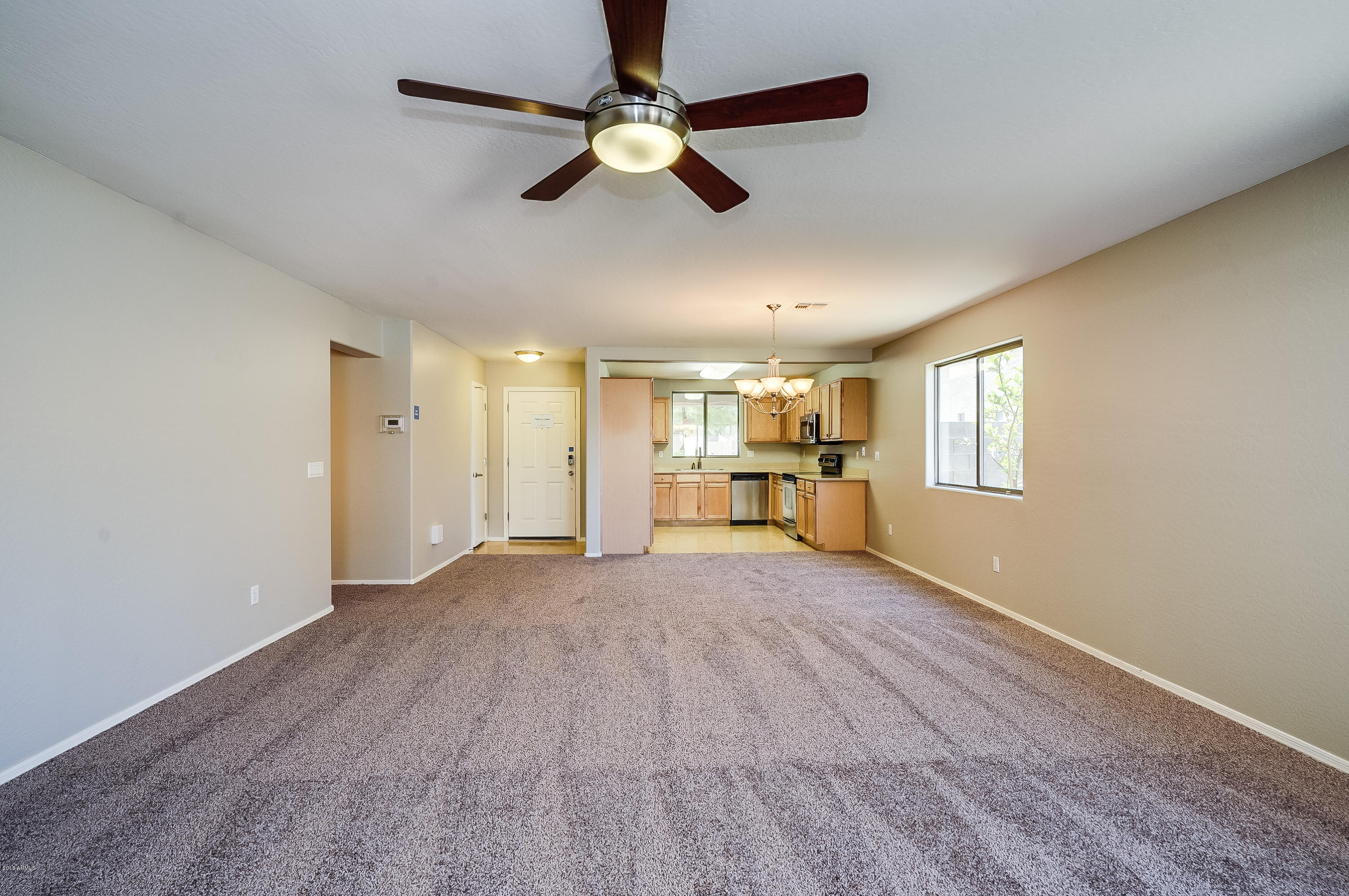 3718 West Carter Road Phoenix, AZ 85041 - Photo 5 of 20 a view of empty room with wooden floor and window