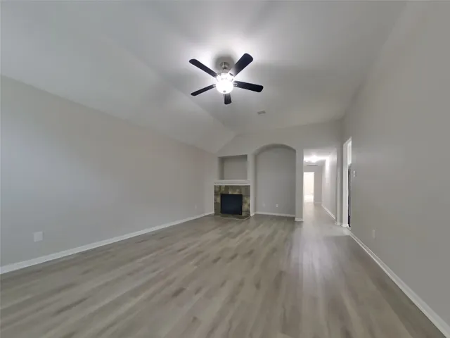 a view of a livingroom with a ceiling fan window and wooden floor
