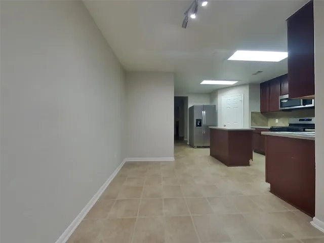 a kitchen with granite countertop a refrigerator and a sink