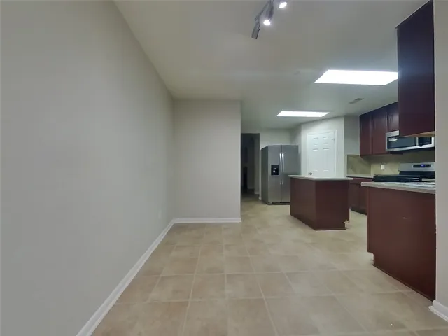 a kitchen with granite countertop a refrigerator and a sink